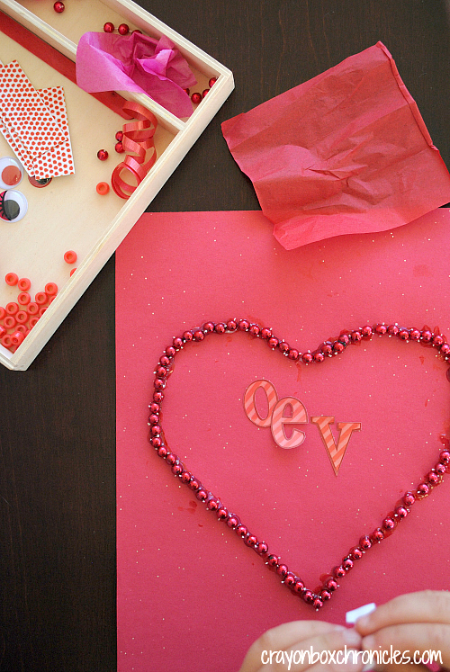 Beads glued around outline of heart with letters LOVE