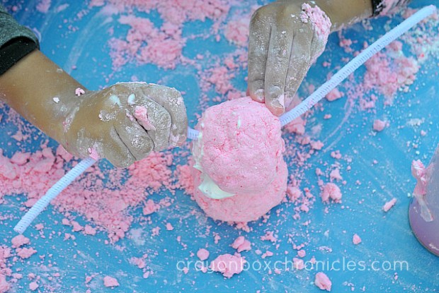 child adding pipe cleaner whiskers to raspberry foam dough bunny